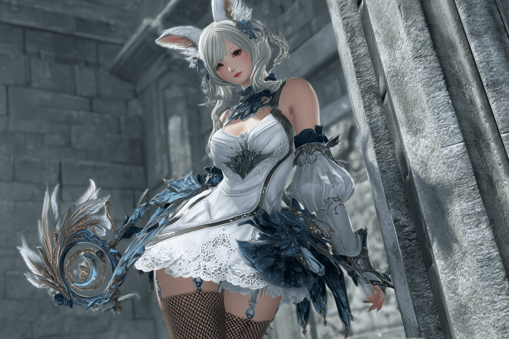 A fantasy character with long, light-colored hair and bunny ears, dressed in an ornate white and blue outfit, holding a decorated staff, set against a stone wall backdrop.