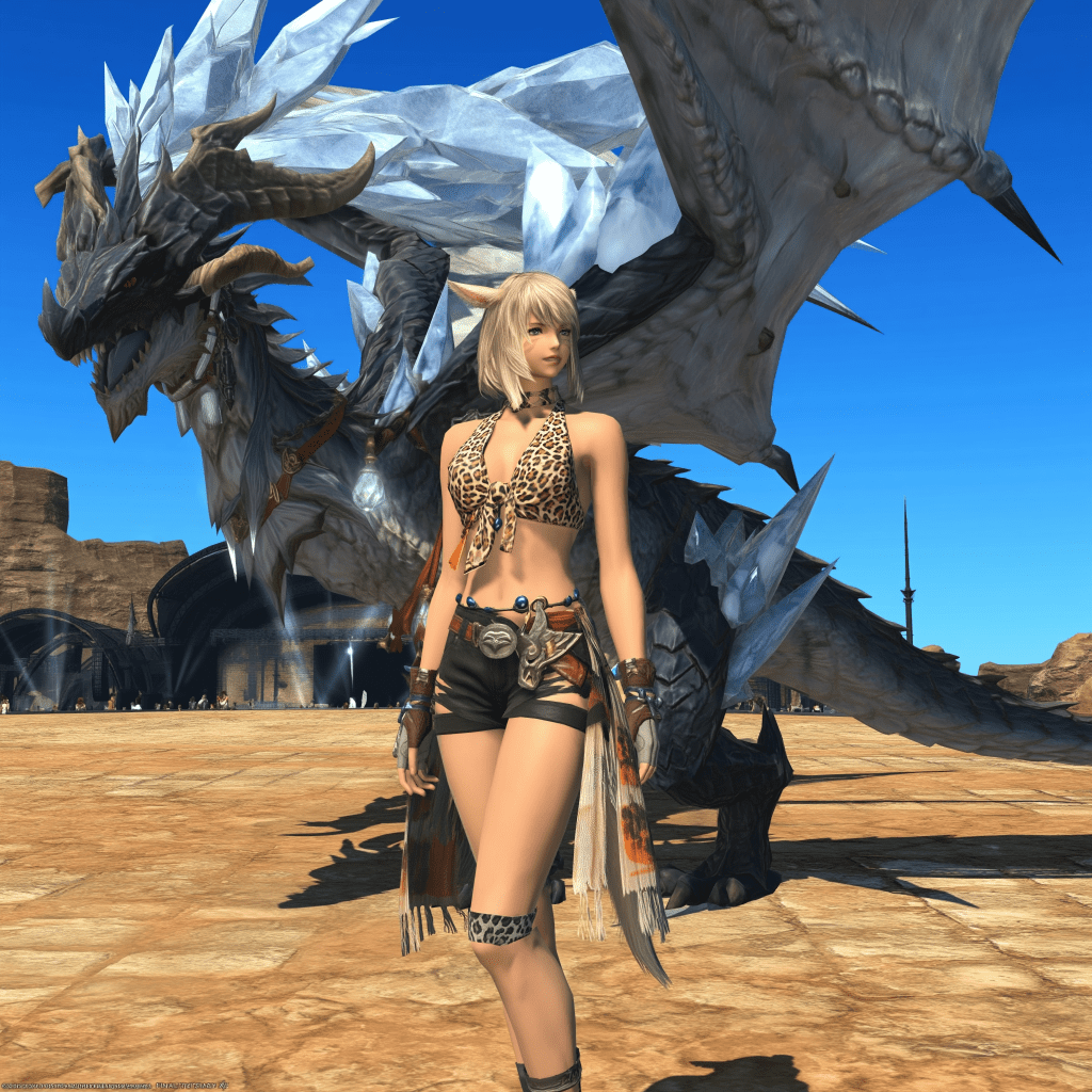 A female character stands confidently in front of a large, majestic dragon with crystal-like wings in a desert-like environment, wearing a leopard print top and shorts.