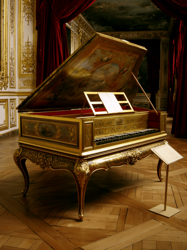 An ornate harpsichord with a decorative lid, set in a lavishly decorated room with red curtains and wooden flooring.